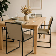 The Joelle dining chair styled in a modern setup, emphasizing its sleek iron leg design.